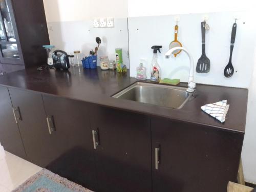 乌纳瓦图纳Sea & Greens Apartments的厨房柜台配有不锈钢水槽