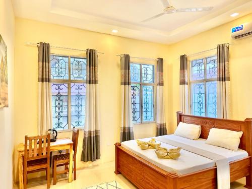南威Garden pearls的卧室配有床、桌子和窗户。