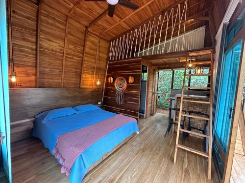 圣拉菲尔Eco Hotel Samaria , Aguas y Bosques的木制客房内的一间卧室,配有一张床