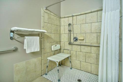 贝克斯菲尔德贝克斯菲尔德6号公寓式酒店的带淋浴的浴室,配有凳子