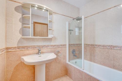 洛斯克里斯蒂亚诺斯Port Royal ocean view apartment in Los Cristianos的一间带水槽和淋浴的浴室