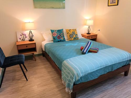 别克斯Lazy Guesthouse的一间卧室配有一张床、一把椅子和两盏灯。