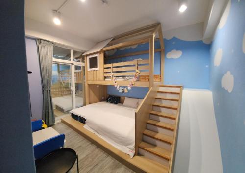 台东铁道小屋民宿 的蓝色墙壁的客房内的双层床