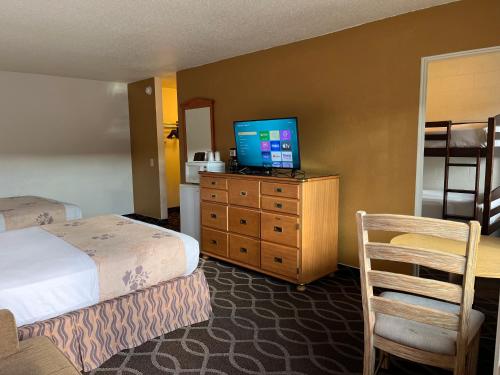 彭德尔顿Americas Best Value Inn - Pendleton的酒店客房,配有床铺和梳妆台上的电视