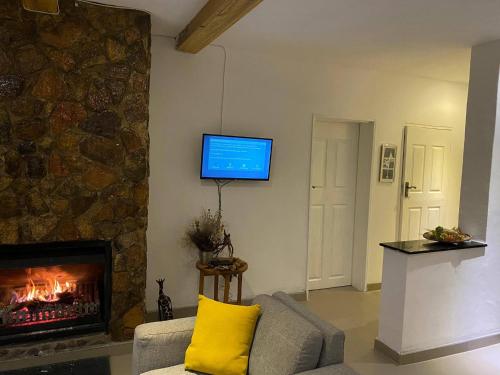 JuliasdaleMsasa Views Cottage的客厅设有壁炉和墙上的电视