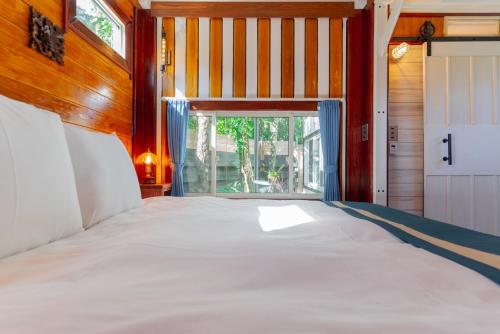 今归仁村Vacation Village Okinawa - Yambaru的窗户客房内的一张大床