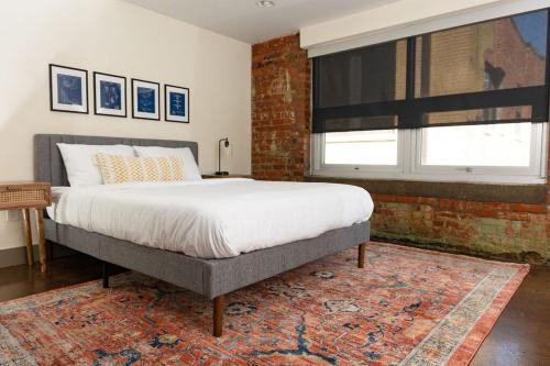 罗阿诺Stunning 2 Br Loft Smack In The Heart Of Downtown的一间卧室设有一张床和砖墙