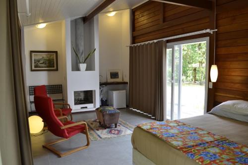 蜜岛Casa da Ilha do Mel - Pousada de Charme的一间卧室配有一张床、一把椅子和一个壁炉