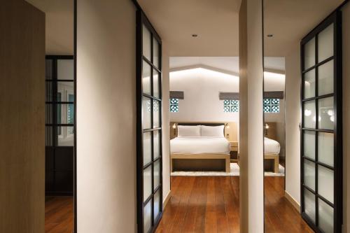 新加坡KēSa House, The Unlimited Collection managed by The Ascott Limited的一间卧室配有一张床和镜子