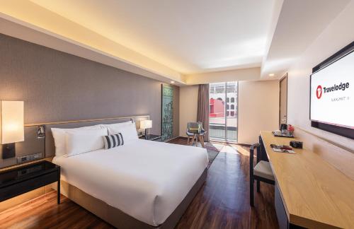 曼谷Travelodge Sukhumvit 11的配有一张床和一台平面电视的酒店客房