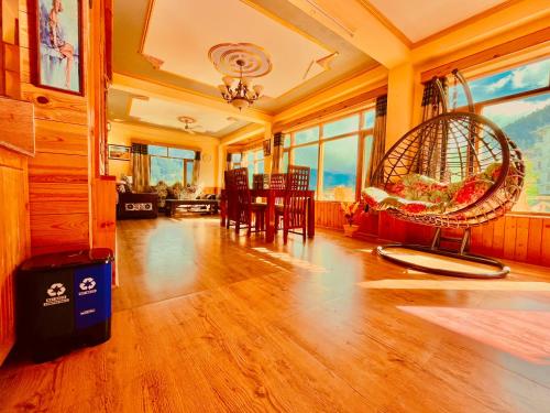 马拉里Shree Ram Cottage, Manali ! 1,2,3 Bedroom Luxury Cottages Available的客厅配有桌椅和秋千