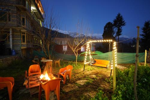 马拉里Shree Ram Cottage, Manali ! 1,2,3 Bedroom Luxury Cottages Available的一群椅子和灯在院子里晚上