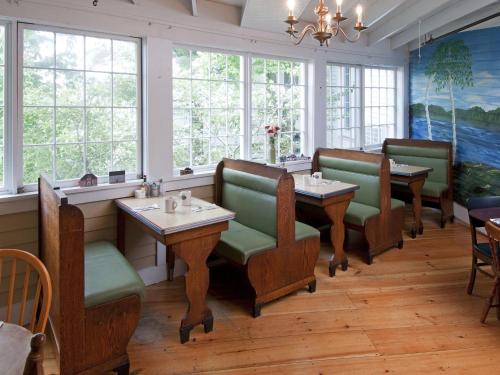 梅勒迪斯湖畔米尔瀑布酒店的餐厅设有桌椅和窗户。