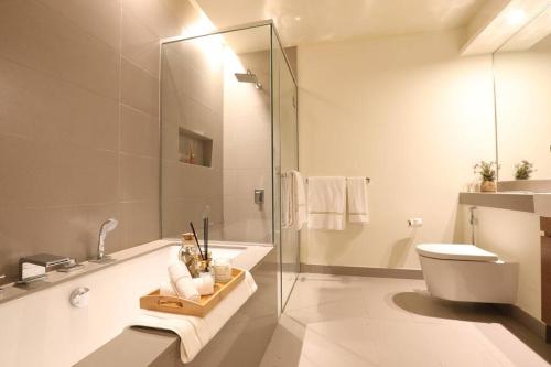 迪拜Manzil - Sleek 2BR nr Downtown & Dubai Mall的一间带玻璃淋浴和卫生间的浴室