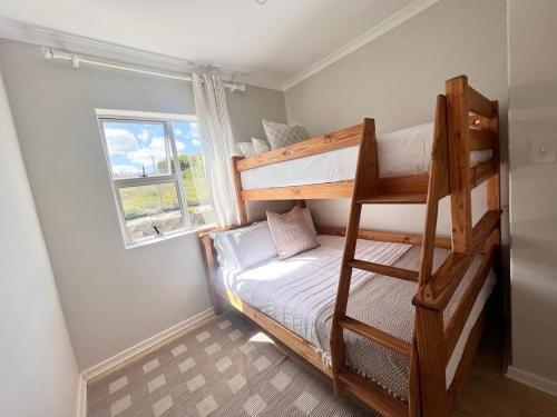 开普敦Bella Casa - Seaview-Beach Club Apartment的小房间设有双层床和窗户