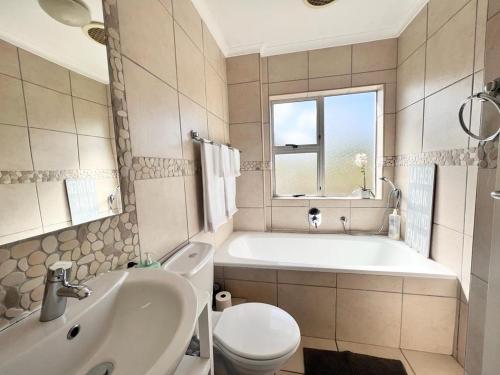 开普敦Bella Casa - Seaview-Beach Club Apartment的带浴缸、卫生间和盥洗盆的浴室