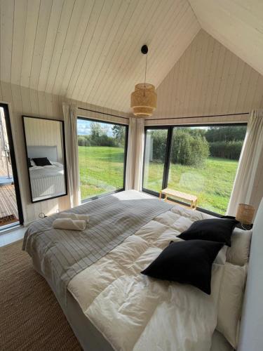 MatīšiPļavas vidū - romantiska brīvdienu māja的一间卧室设有一张大床和大窗户