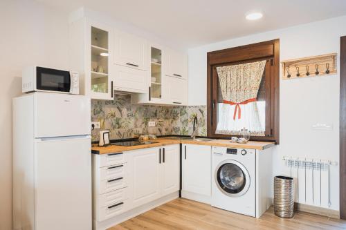 阿尔苏阿Apartamentos Luis的厨房配有白色橱柜、洗衣机和烘干机