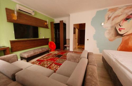 阿斯塔纳Inn OZZ Astana的客厅配有沙发和一幅女人画