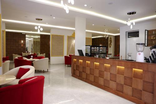 阿尔阿尔فندق الزوين - Alzuwain Hotel的餐厅设有酒吧,配有红色的椅子和桌子