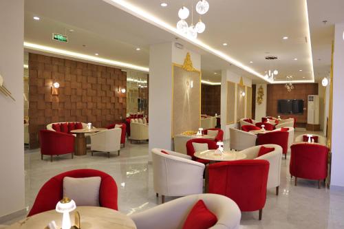 阿尔阿尔فندق الزوين - Alzuwain Hotel的餐厅设有红色和白色的椅子和桌子