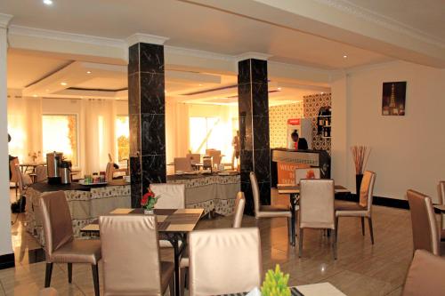 卢萨卡Fatmols Hotels的一间在房间内配有桌椅的餐厅