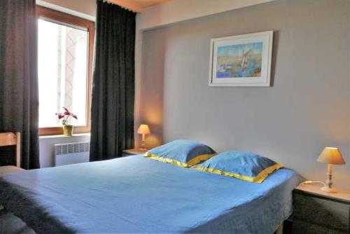 奥斯坦德De Strandwandeling 0203 Appartement met frontaal zeezicht的一间卧室设有蓝色的床和窗户。