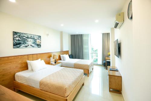 胡志明市Mia Hotel的酒店客房设有两张床和电视。