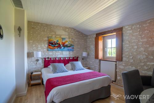 阿瓦耶Le Pigeonnier du Perron Hôtel的一间卧室配有一张大床和红色床头板