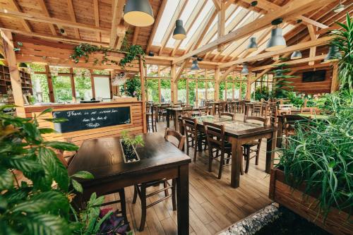 布莱德布莱德花园村帐篷营地的餐厅设有木桌和椅子,种有植物