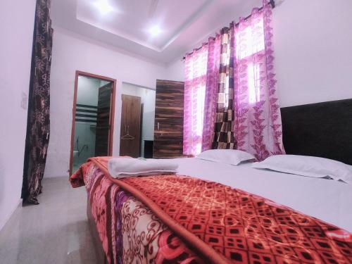 钱德加尔Hotel Yolo的一间卧室配有一张带红色棉被的床和窗户。