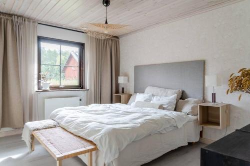 乌普萨拉A countryside villa close to Uppsala!的白色的卧室设有一张大床和一个窗户