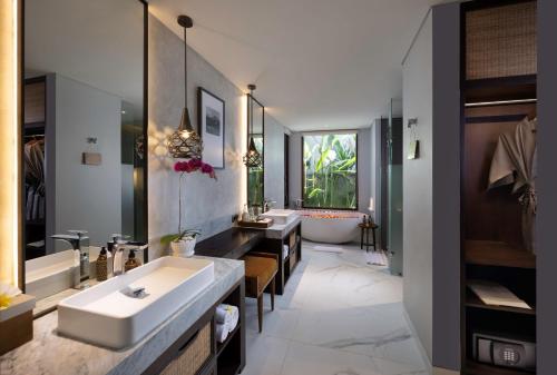乌布The Hava Ubud A Pramana Experience的浴室配有两个盥洗盆和浴缸。