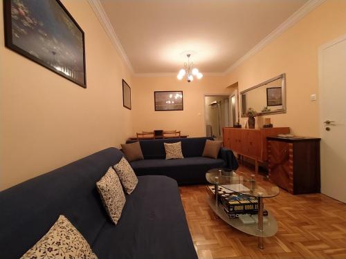 塞萨洛尼基Cozy three BDRMS central APT at five Filippou str的客厅配有蓝色的沙发和玻璃桌