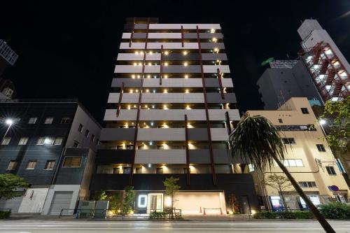 东京stayme THE HOTEL Asakusa Riverside的一座高大的建筑,晚上有灯