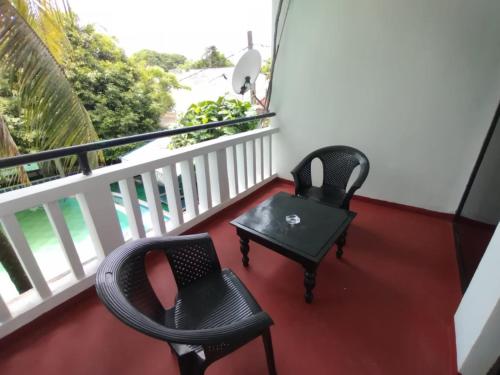 WatumullaHotel Mount Lanka的阳台配有2把椅子和桌子