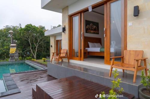 库布盼洛坎Sari Sky Bali的一间卧室和一座游泳池的别墅