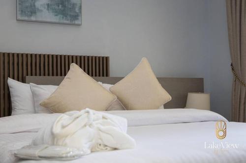 海岸角Standard Room in Cape Coast - Lakeview by Agnes的一间卧室配有两张带白色床单和枕头的床。