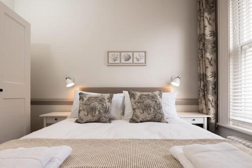 索尔兹伯里3 Castle Mews的卧室配有白色的床和2个枕头