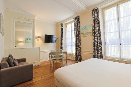 凯恩弗朗索瓦德奥酒店的一间卧室配有一张床、一张沙发和一张桌子