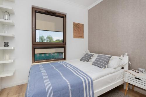 格但斯克Modern Apartment with Balcony by Renters的卧室配有白色的床和窗户。