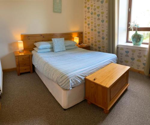 瑟索Thurso Bay Holidays的一间卧室配有一张床、一张桌子和一个窗户。
