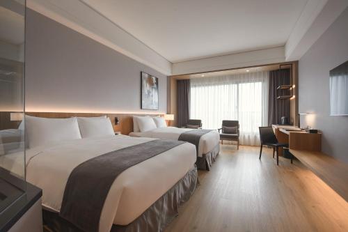 台南禧榕轩大饭店的酒店客房配有两张床和一张书桌