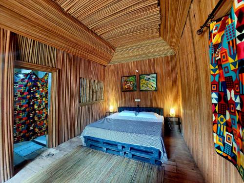 OuidahBel Ami的木制客房内的一间卧室,配有一张床
