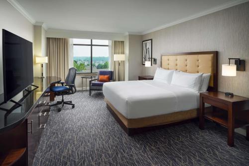 里士满Hilton Richmond Hotel & Spa Short Pump的酒店客房设有一张大床和一台电视。
