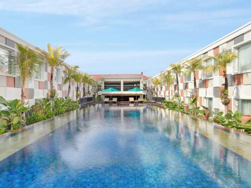 库塔巴厘岛国际机场诺富特酒店的一座建筑物中央的游泳池
