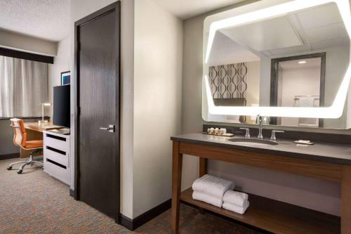 史密斯堡Wyndham Fort Smith City Center的酒店客房设有水槽和镜子