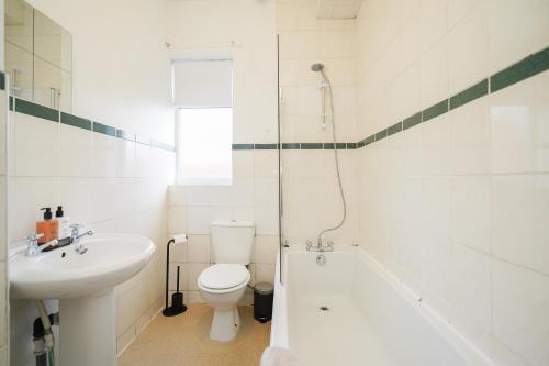 谢菲尔德Stadium View, entire private house, close to city centre, free WiFi的浴室配有盥洗盆、卫生间和浴缸。