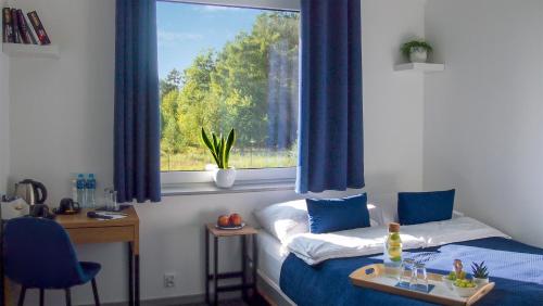 格但斯克Mile Gdansk Airport的客房设有两张床和一扇带蓝色窗帘的窗户。