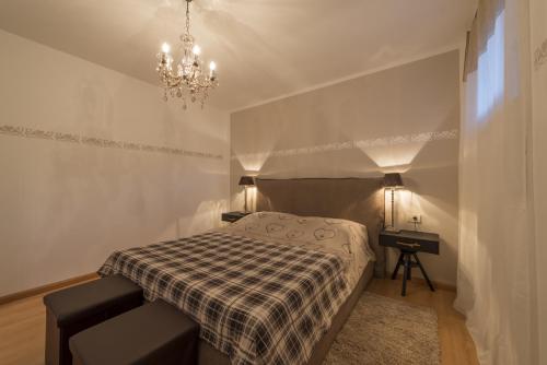 里约·迪·普斯特里亚Apartment Sofia的一间带一张床和吊灯的小卧室